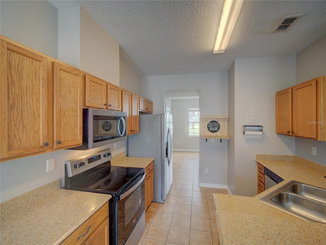 7462 Bentonshire Ave, Windermere, FL 34786 - kitchen featuring appliances with stainless steel finishes, light countertops, light tile patterned floors, and a textured ceiling