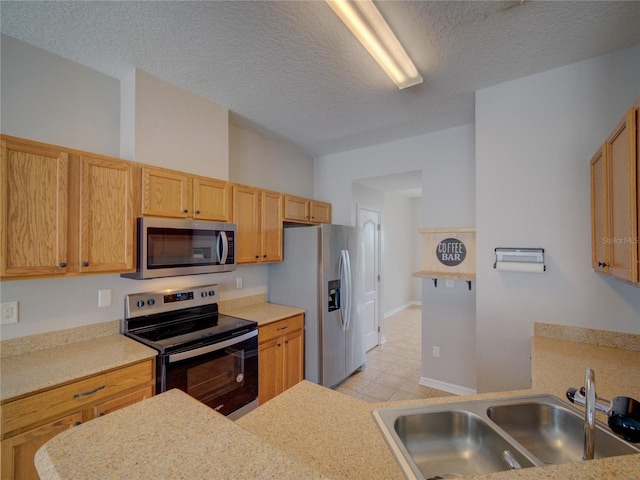 7462 Bentonshire Ave, Windermere, FL 34786 - kitchen with appliances with stainless steel finishes, a textured ceiling, light countertops, and light tile patterned floors
