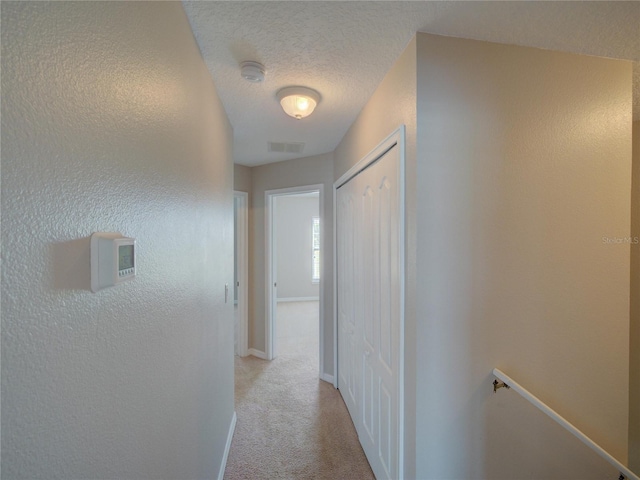 7462 Bentonshire Ave, Windermere, FL 34786 - hallway with an upstairs landing, light colored carpet, and a textured ceiling