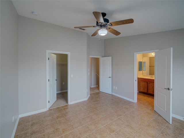 7462 Bentonshire Ave, Windermere, FL 34786 - unfurnished bedroom with light tile patterned floors, connected bathroom, a ceiling fan, and a walk in closet