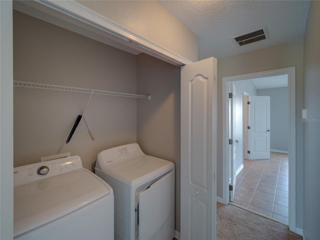 7462 Bentonshire Ave, Windermere, FL 34786 - washroom with washing machine and dryer, light tile patterned floors, light colored carpet, and a textured ceiling