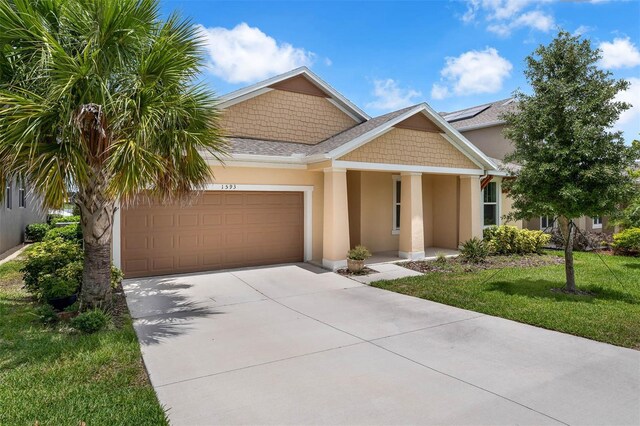 1593 Osprey View Dr, Apopka, FL 32703 - view of front of house with stucco siding, driveway, an attached garage, a front lawn, and covered porch