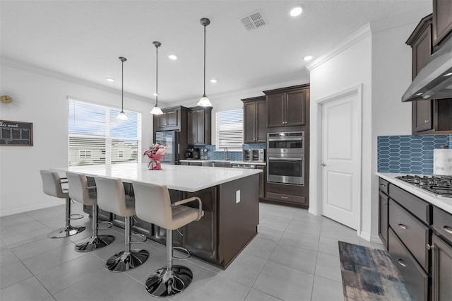 1593 Osprey View Dr, Apopka, FL 32703 - kitchen with stainless steel appliances, exhaust hood, crown molding, tasteful backsplash, and dark brown cabinets