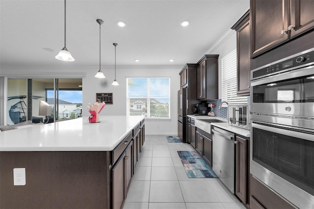 1593 Osprey View Dr, Apopka, FL 32703 - kitchen featuring stainless steel appliances, dark brown cabinets, ornamental molding, light countertops, and light tile patterned floors
