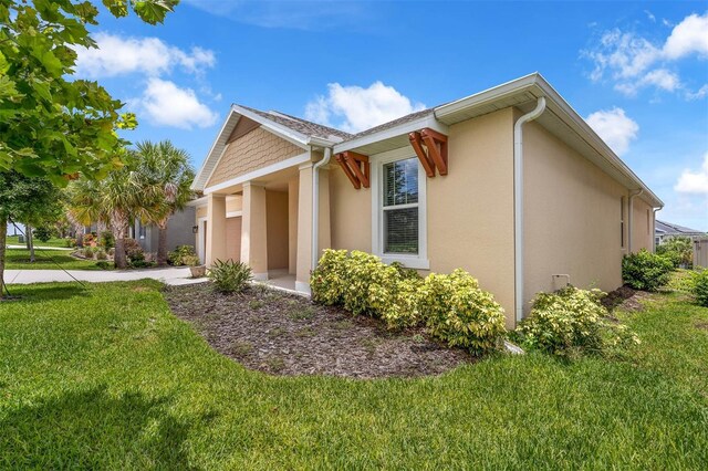 1593 Osprey View Dr, Apopka, FL 32703 - view of side of property with an attached garage, stucco siding, a lawn, and concrete driveway