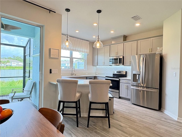 4171 Via Sienna Cir, Sarasota, FL 34243 - kitchen with stainless steel appliances, decorative backsplash, light countertops, a peninsula, and a breakfast bar area