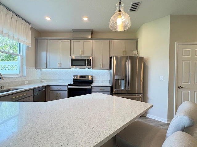 4171 Via Sienna Cir, Sarasota, FL 34243 - kitchen featuring appliances with stainless steel finishes, gray cabinetry, tasteful backsplash, and recessed lighting