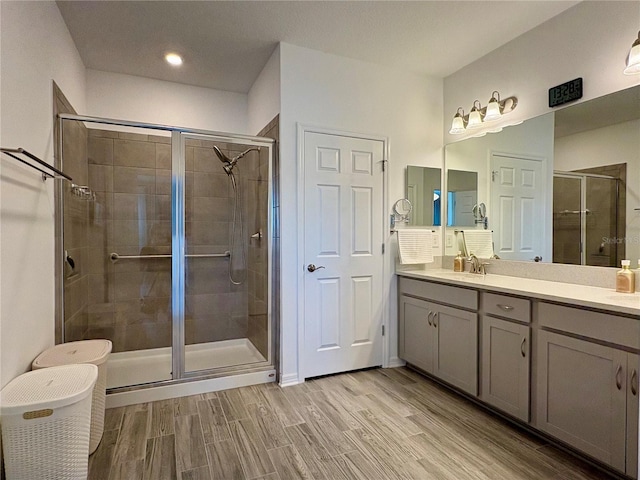 4171 Via Sienna Cir, Sarasota, FL 34243 - full bathroom with a shower stall, double vanity, and wood finished floors