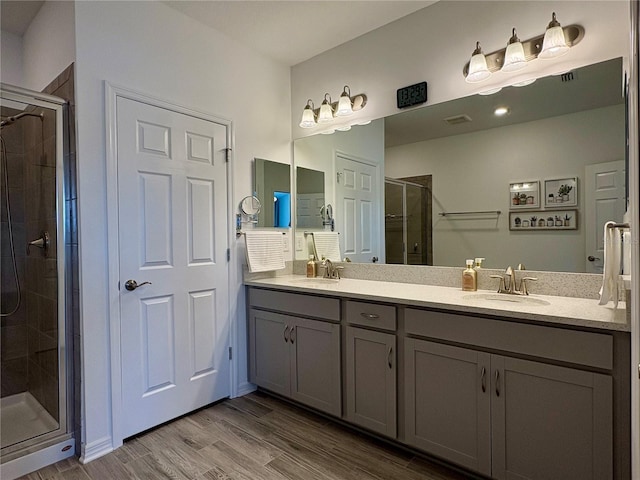 4171 Via Sienna Cir, Sarasota, FL 34243 - full bathroom with a stall shower, double vanity, and wood finished floors