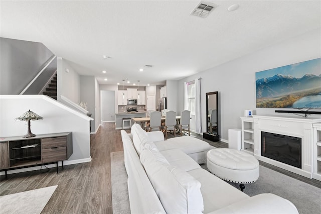 2345 Volunteer Ave, Kissimmee, FL 34744 - living room with wood finished floors, stairs, recessed lighting, and a glass covered fireplace