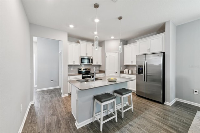2345 Volunteer Ave, Kissimmee, FL 34744 - kitchen featuring stainless steel appliances, dark wood finished floors, a kitchen island with sink, white cabinetry, and recessed lighting