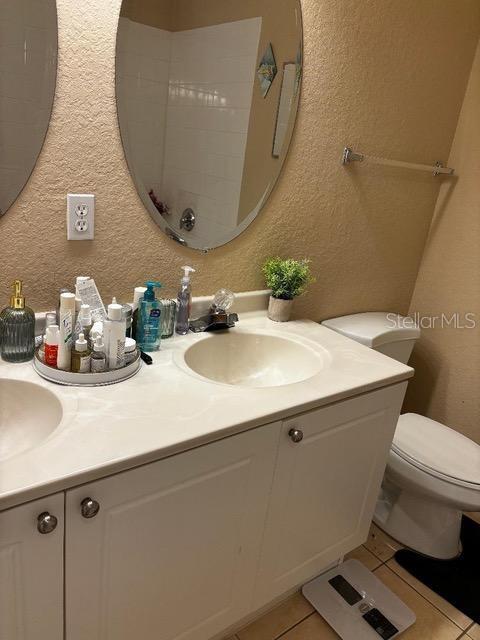 2536 Lancien Ct Unit 5, Orlando, FL 32826 - bathroom featuring a textured wall, double vanity, and tile patterned flooring