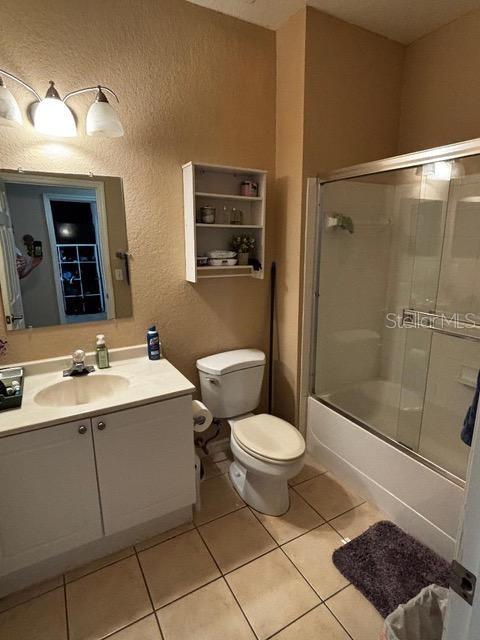 2536 Lancien Ct Unit 5, Orlando, FL 32826 - bathroom with a textured wall, vanity, combined bath / shower with glass door, and tile patterned floors