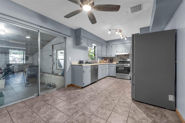 905 Flewelling Ave, Ocoee, FL 34761 - kitchen with appliances with stainless steel finishes, light countertops, a ceiling fan, under cabinet range hood, and tasteful backsplash