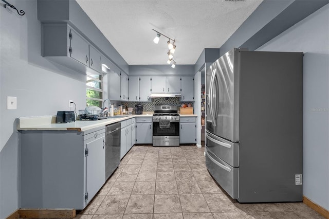 905 Flewelling Ave, Ocoee, FL 34761 - kitchen with stainless steel appliances, light countertops, under cabinet range hood, tasteful backsplash, and a textured ceiling