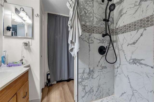 905 Flewelling Ave, Ocoee, FL 34761 - full bath featuring vanity, a marble finish shower, wood finished floors, and a textured ceiling