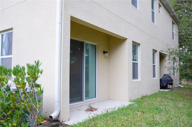 3569 Seneca Club Loop Unit 13, Orlando, FL 32808 - view of home's exterior featuring stucco siding and a yard