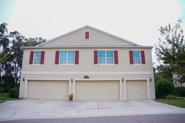 3569 Seneca Club Loop Unit 13, Orlando, FL 32808 - view of front of home with an attached garage, driveway, and stucco siding