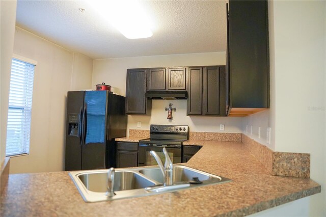 3569 Seneca Club Loop Unit 13, Orlando, FL 32808 - kitchen with black appliances, under cabinet range hood, dark brown cabinetry, and light countertops