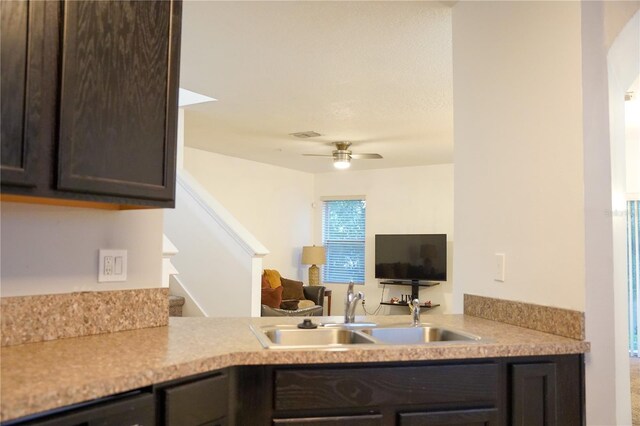 3569 Seneca Club Loop Unit 13, Orlando, FL 32808 - kitchen featuring dark brown cabinetry, light countertops, ceiling fan, and open floor plan