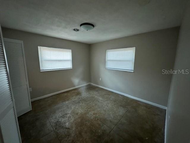 4732 Luce Rd, Lakeland, FL 33813 - unfurnished bedroom featuring multiple windows and concrete flooring