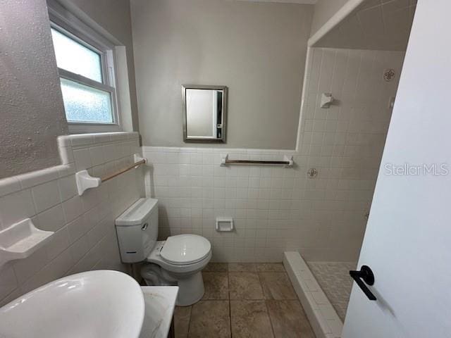 4732 Luce Rd, Lakeland, FL 33813 - full bath with tile walls, a stall shower, tile patterned flooring, and a wainscoted wall