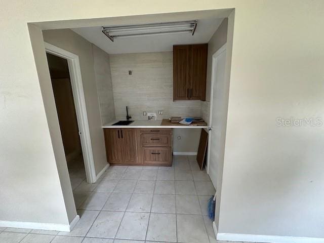 4732 Luce Rd, Lakeland, FL 33813 - kitchen featuring light tile patterned floors, light countertops, and brown cabinets
