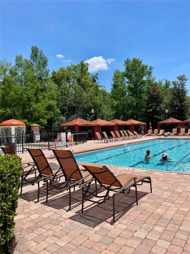 8010 Tuscany Way Unit 3102, Davenport, FL 33896 - community pool with a patio area, a gazebo, and view of wooded area