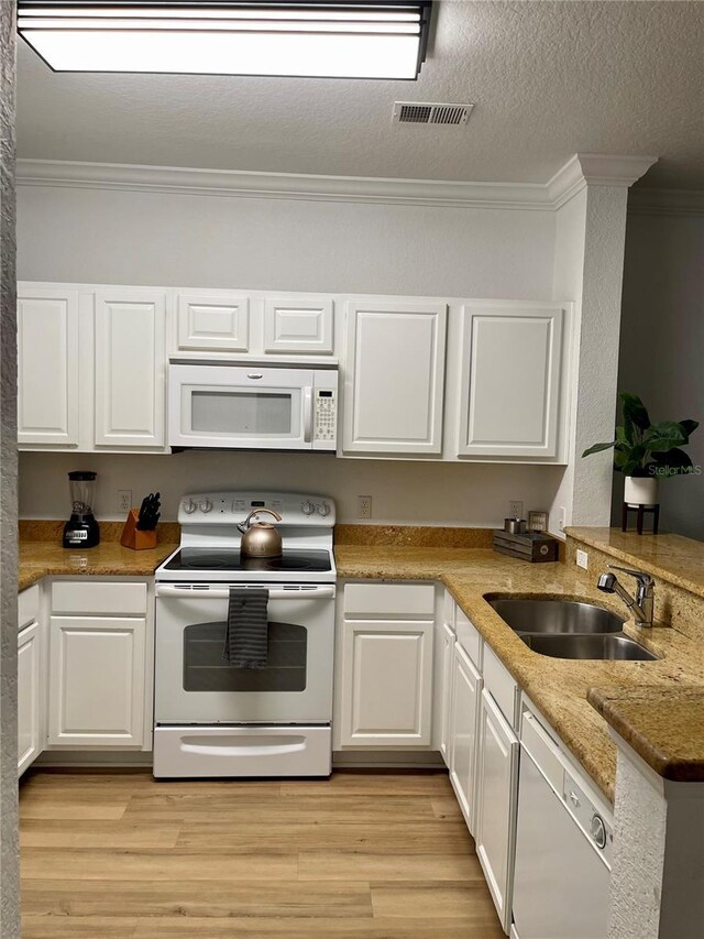 8010 Tuscany Way Unit 3102, Davenport, FL 33896 - kitchen featuring white appliances, crown molding, white cabinets, light wood-style flooring, and a peninsula