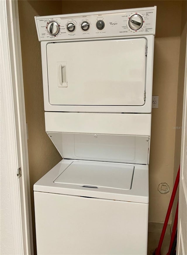 8010 Tuscany Way Unit 3102, Davenport, FL 33896 - laundry area featuring stacked washer and clothes dryer and a textured wall