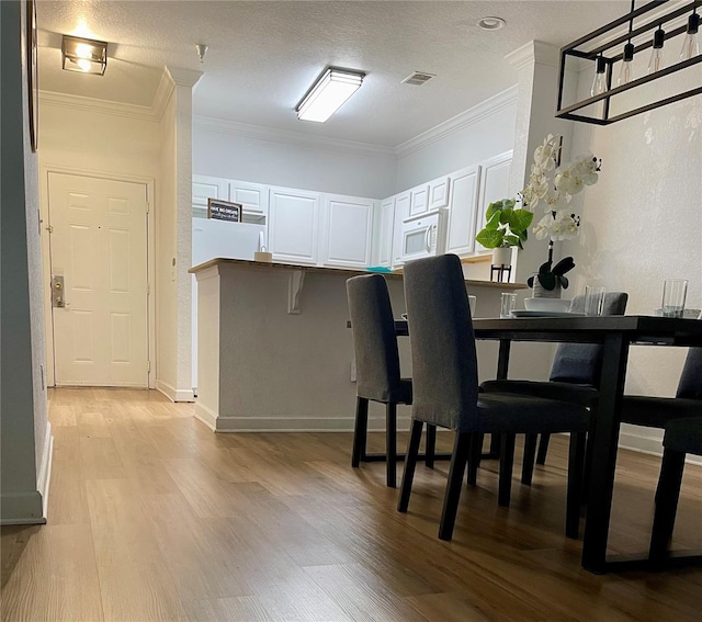 8010 Tuscany Way Unit 3102, Davenport, FL 33896 - dining area with light wood-type flooring and ornamental molding