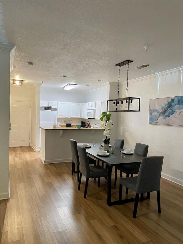 8010 Tuscany Way Unit 3102, Davenport, FL 33896 - dining area featuring ornamental molding, light wood-style floors, and a textured ceiling