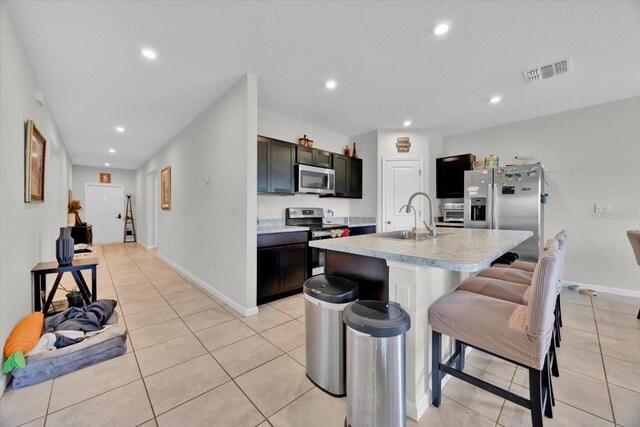 145 Piave St, Haines City, FL 33844 - kitchen featuring stainless steel appliances, light countertops, light tile patterned flooring, a kitchen breakfast bar, and recessed lighting