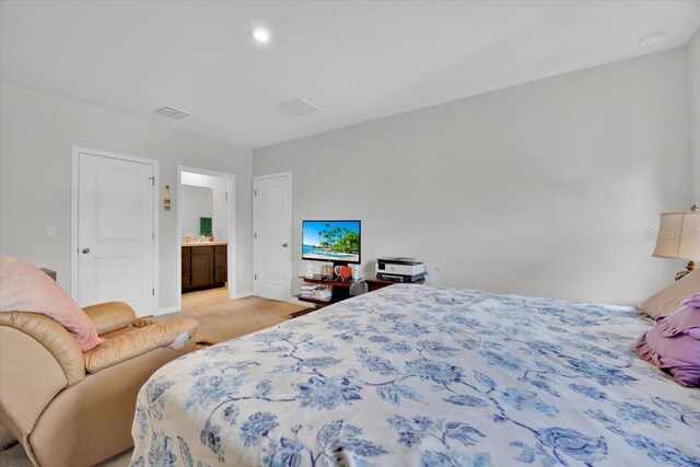 145 Piave St, Haines City, FL 33844 - bedroom with light colored carpet, ensuite bathroom, and recessed lighting