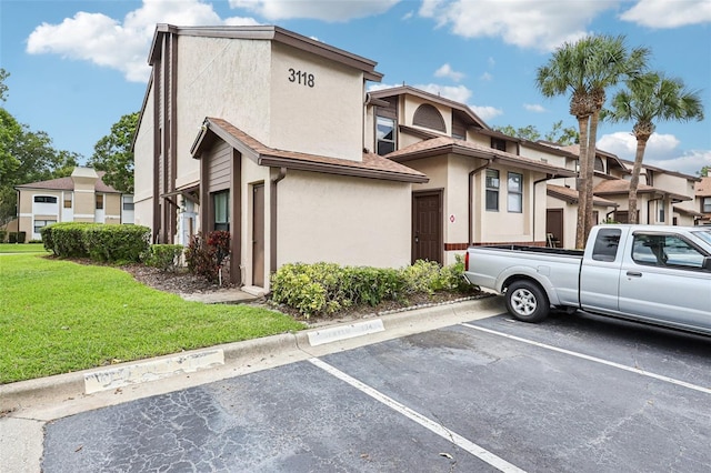 3118 S Semoran Blvd Unit 2, Orlando, FL 32822 - view of front of house with stucco siding, uncovered parking, and a front lawn