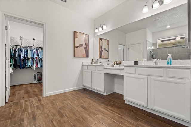 922 Grazie Loop, Davenport, FL 33837 - bathroom with double vanity, a tile shower, wood finished floors, and a spacious closet