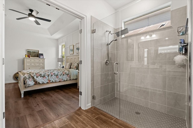 922 Grazie Loop, Davenport, FL 33837 - bathroom with ensuite bathroom, a stall shower, a ceiling fan, wood finished floors, and a raised ceiling