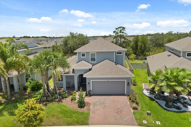 922 Grazie Loop, Davenport, FL 33837 - view of front of house featuring a shingled roof, a garage, decorative driveway, stucco siding, and a residential view