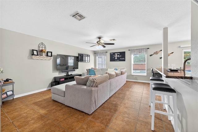1224 Blackwater Pond Dr, Orlando, FL 32828 - living area with tile patterned flooring, a ceiling fan, and a textured ceiling