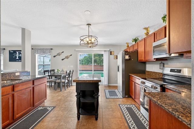 1224 Blackwater Pond Dr, Orlando, FL 32828 - kitchen featuring stainless steel appliances, a chandelier, a textured ceiling, decorative light fixtures, and brown cabinetry