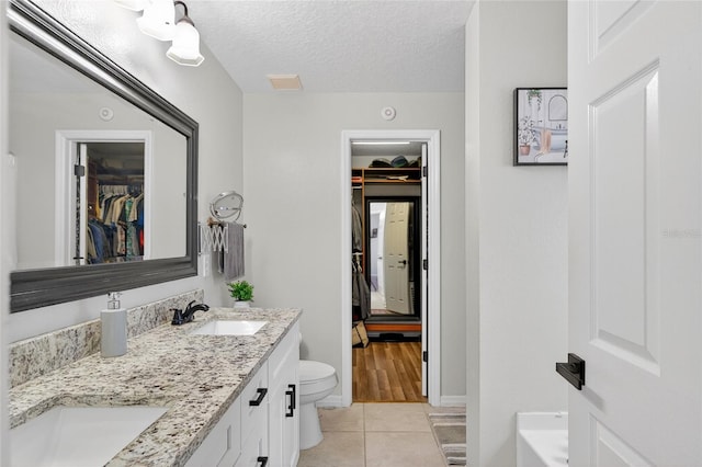 1224 Blackwater Pond Dr, Orlando, FL 32828 - full bathroom featuring tile patterned flooring, double vanity, a textured ceiling, and a spacious closet
