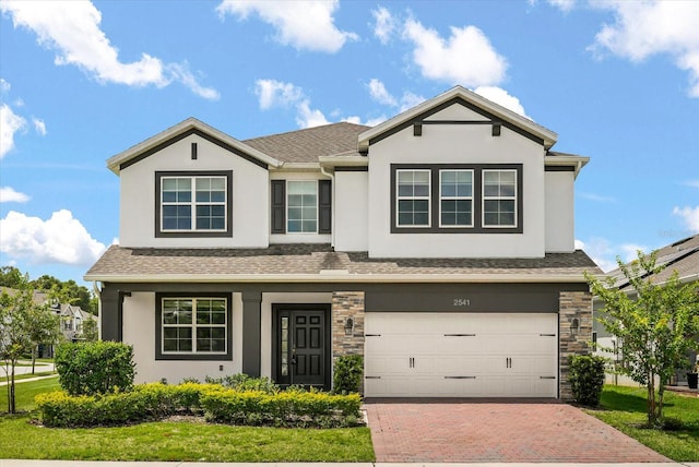 2541 Leyland Cypress Ln, Sanford, FL 32773 - view of front of property with stucco siding, decorative driveway, an attached garage, and roof with shingles