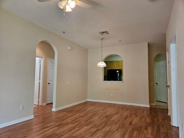 6214 Stevenson Dr Unit 208, Orlando, FL 32835 - empty room with wood finished floors, ceiling fan, arched walkways, and a textured ceiling