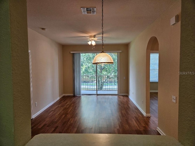 6214 Stevenson Dr Unit 208, Orlando, FL 32835 - unfurnished dining area featuring a ceiling fan, wood finished floors, a textured wall, arched walkways, and a textured ceiling
