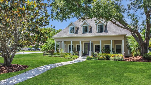 19554 Spring Oak Dr, Eustis, FL 32736 - cape cod house with a front yard, covered porch, a shingled roof, and stucco siding
