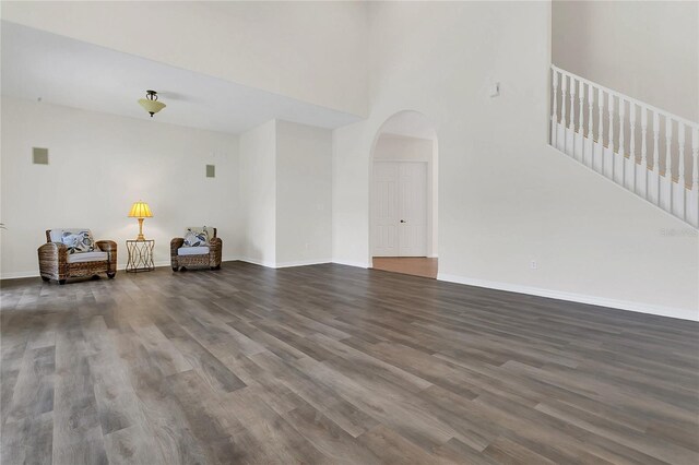 19554 Spring Oak Dr, Eustis, FL 32736 - living area featuring arched walkways, dark wood finished floors, stairway, and a high ceiling