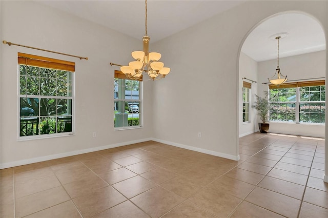 19554 Spring Oak Dr, Eustis, FL 32736 - empty room with tile patterned floors, a chandelier, arched walkways, and plenty of natural light