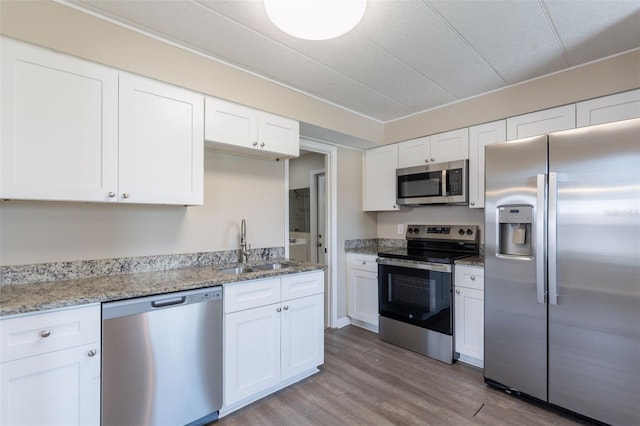 3850 11th Ave S, Saint Petersburg, FL 33711 - kitchen with stainless steel appliances, white cabinets, light wood-style floors, and light stone countertops
