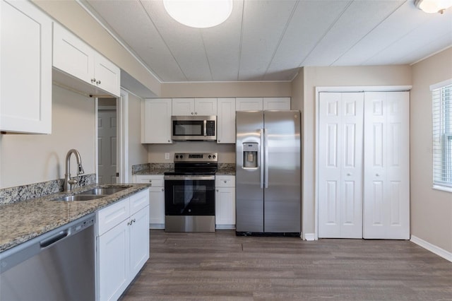 3850 11th Ave S, Saint Petersburg, FL 33711 - kitchen with appliances with stainless steel finishes, dark wood-style flooring, light stone counters, and white cabinets