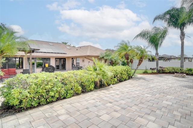 2406 Sweetwater Blvd, Saint Cloud, FL 34772 - rear view of house with french doors, solar panels, a patio, and stucco siding